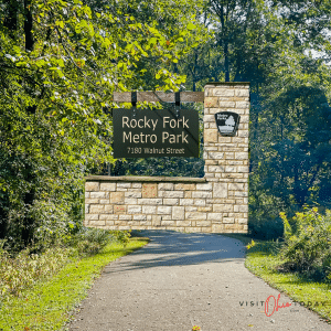overlay picture in picture, background is a paved walking path through forest and the top overlay picture is the rocky fork metro park sign