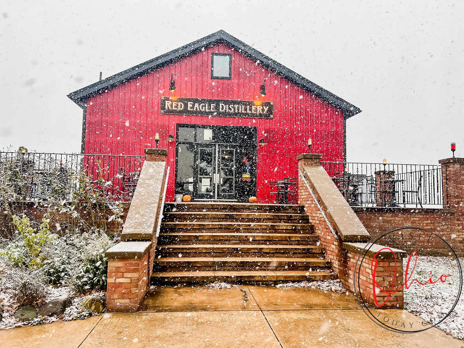 red barn with white snow falling, text red eagle distillery