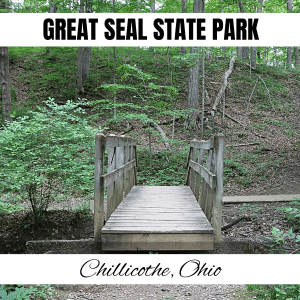 square image with a photo of a wooden bridge in Great Seal State Park. A white strip across the top has the text Great Seal State Park, and a strip across the bottom has the text Chillicothe Ohio. Image Public Domain via Wikimedia Commons