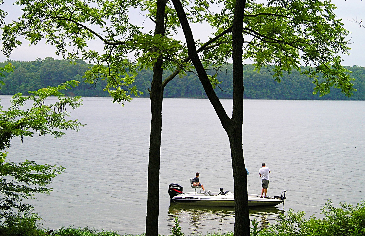 horizontal photo of a couple of people fishing from a boat on the lake at Forked Run State Park