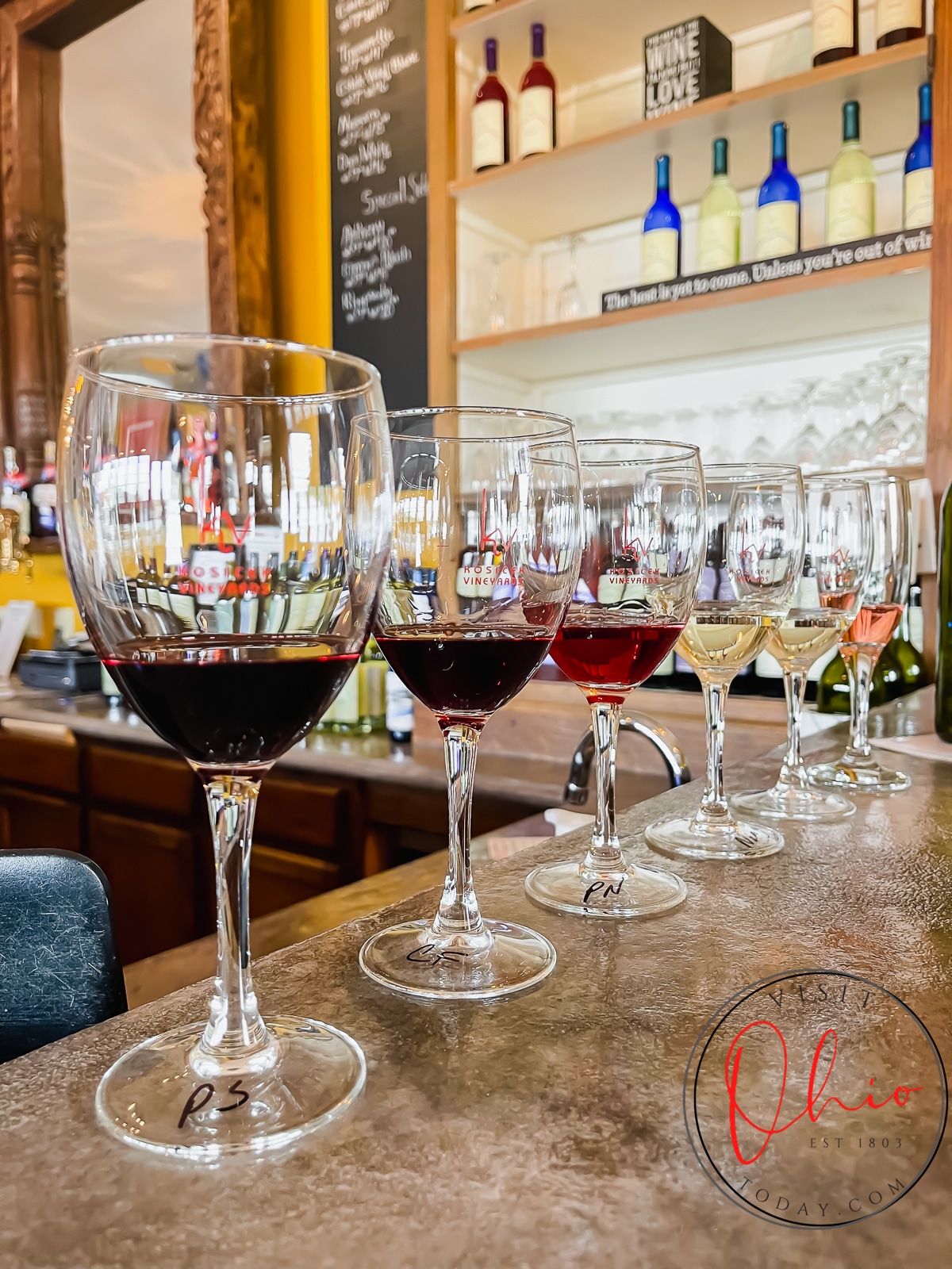 bar setting with 8 wine glasses lined up in a row with red, yellow and pink liquids Photo credit: Cindy Gordon of VisitOhioToday.com