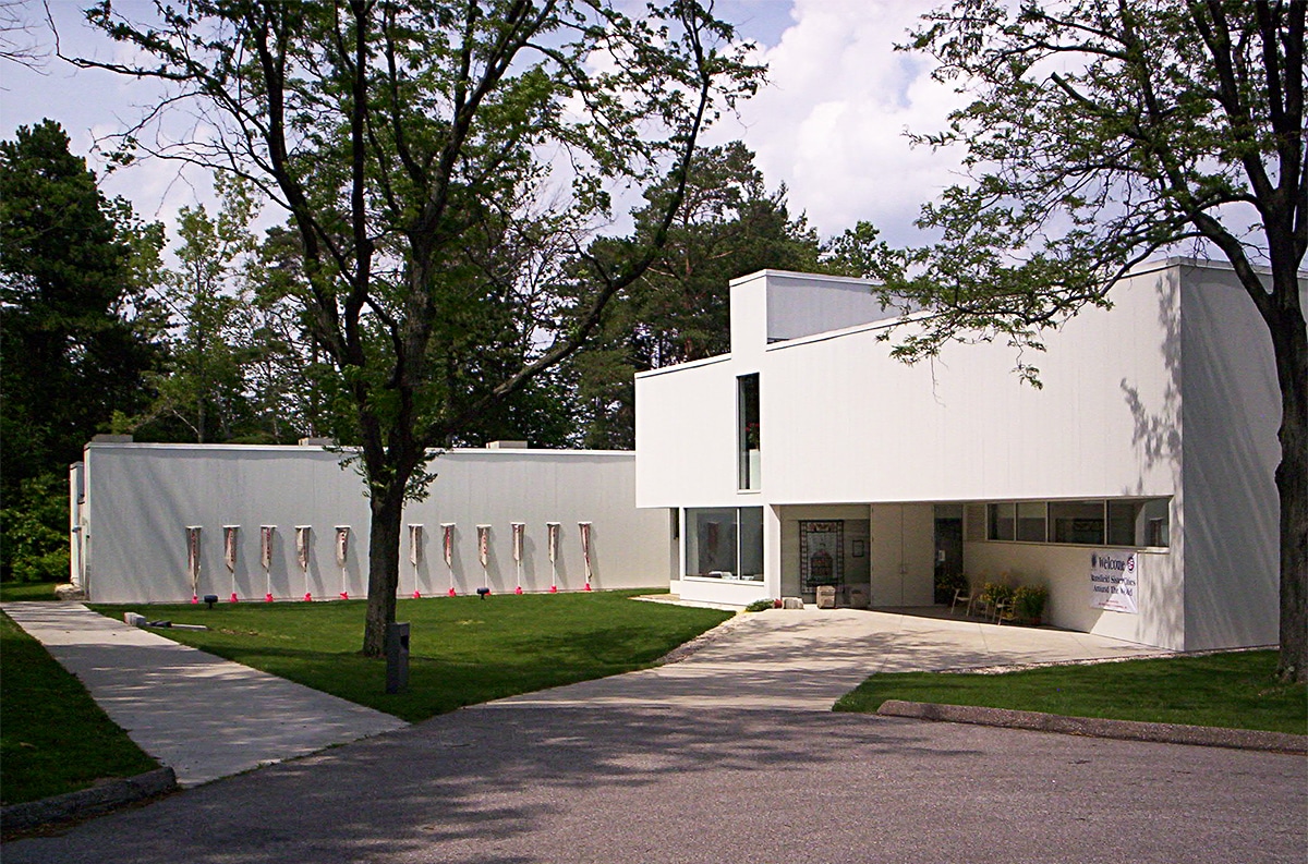 horizontal photo of the Mansfield Art Center with grass and trees in the foreground