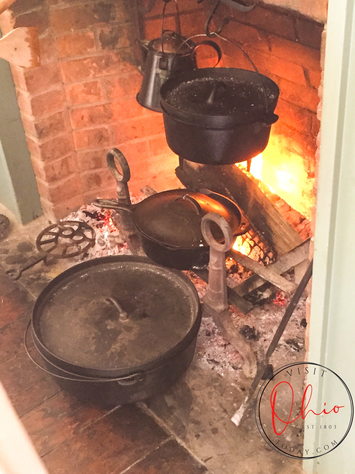 cast iron pots on racks in fireplace at ohio village
