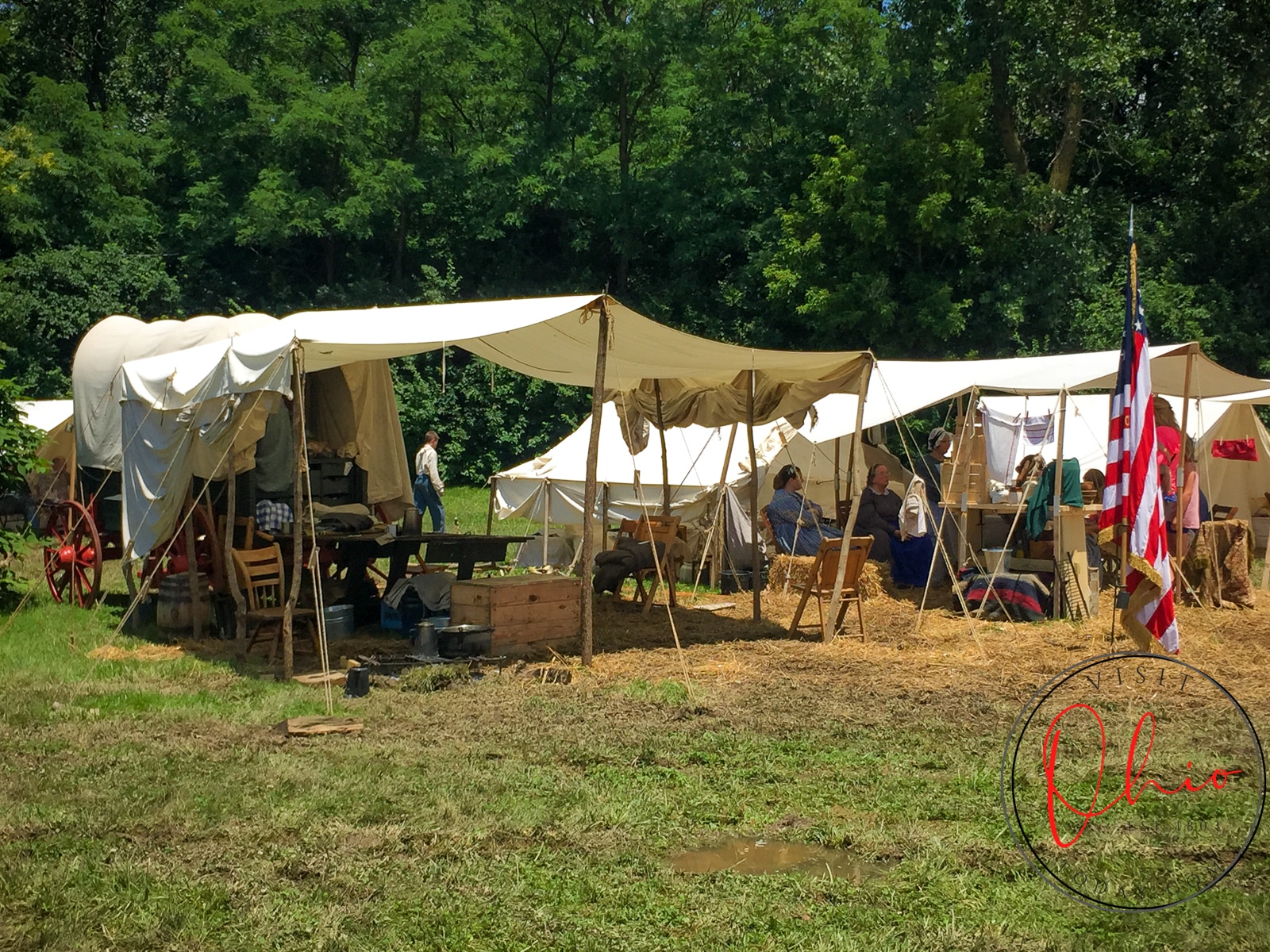 civil war era tents with wooden poles on muddy gass