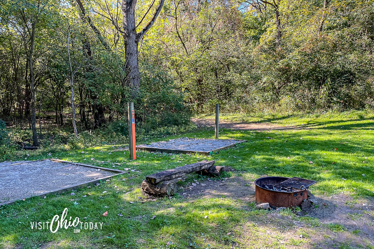 horizontal photo of green grass, camp fire ring, two gravel sqaures for camping Photo credit: Cindy Gordon of VisitOhioToday.com