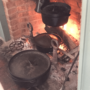 cast iron pots on racks in fireplace at ohio village