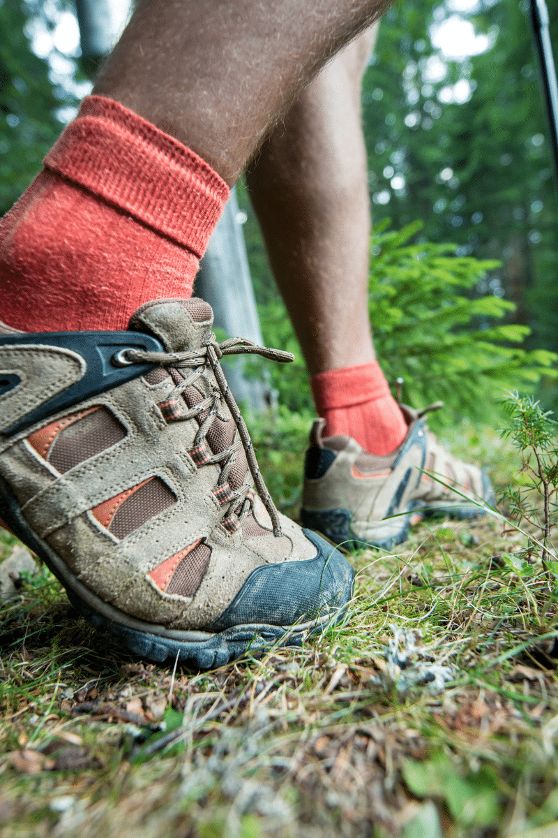 orange sock in brown water shoes waking on green grass path