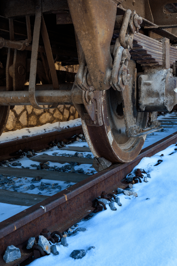 Bottom of a rusty train wheel on a rusty track