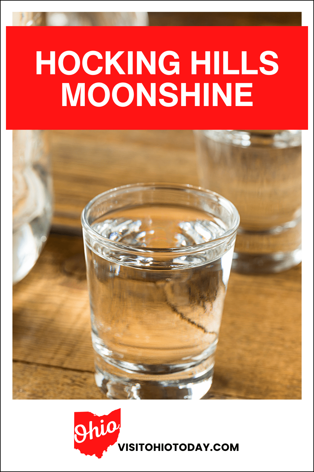 vertical image with a photo of a shot glass of Moonshine on a wooden surface. A red box across the top has the text Hocking Hills Moonshine