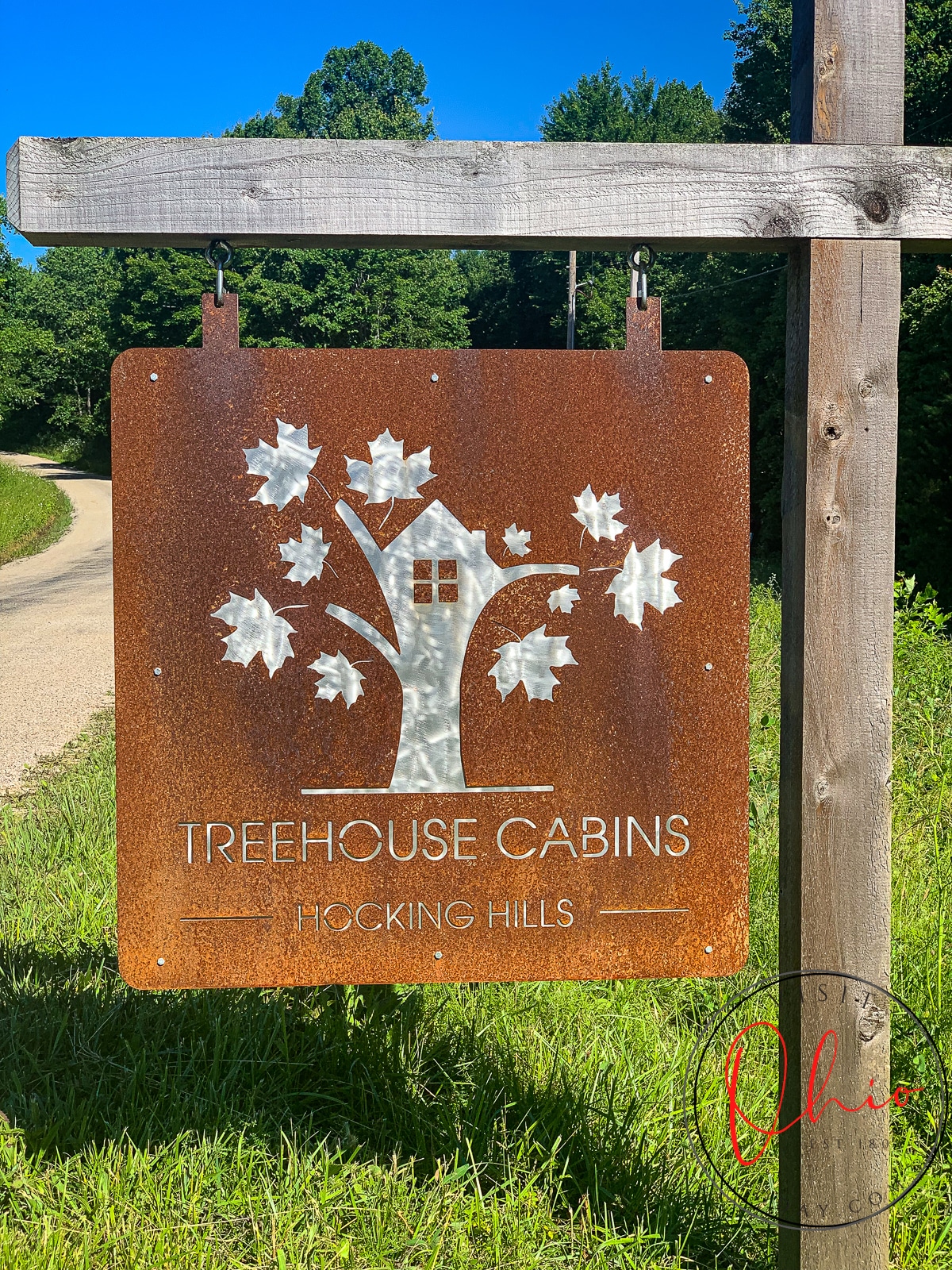 cooper looking sign on a wooden L post with a cut out tree and words hocking hills treehouse cabins and green grass underneath Photo credit: Cindy Gordon of VisitOhioToday.com