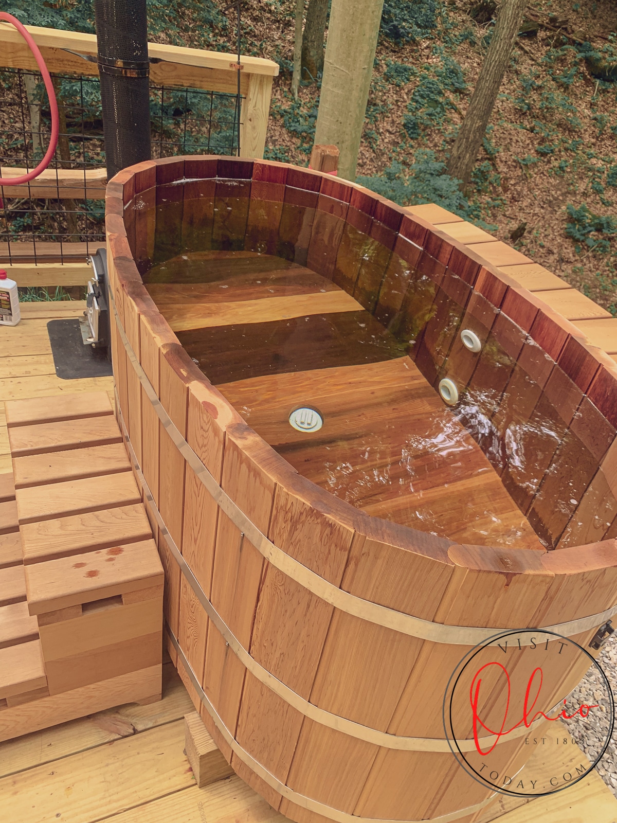 cedar oval tub full of water sitting on wodden deck