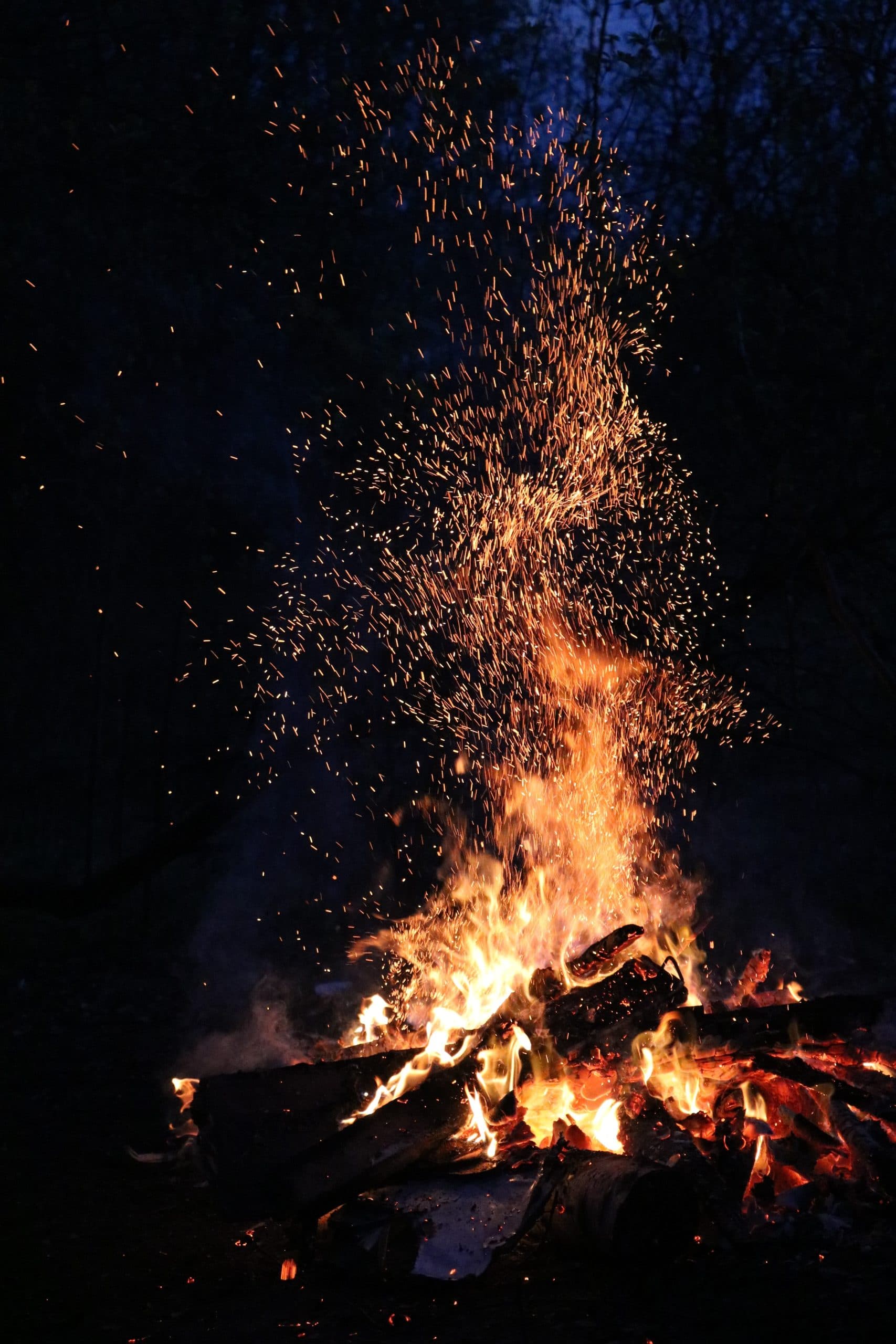 black night sky and a roaring bonfire with tall orange flames