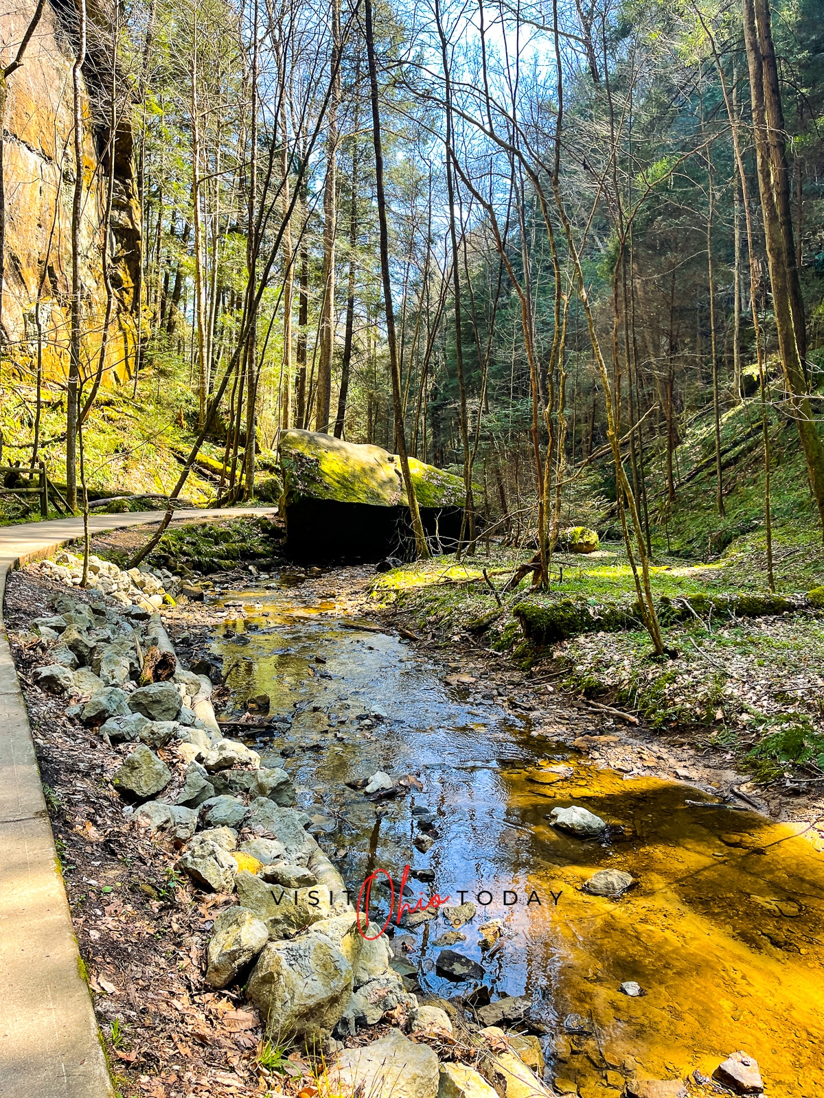 rocky water creek bed with paved path to the left and tall skinny trees with no eaves Photo credit: Cindy Gordon of VisitOhioToday.com