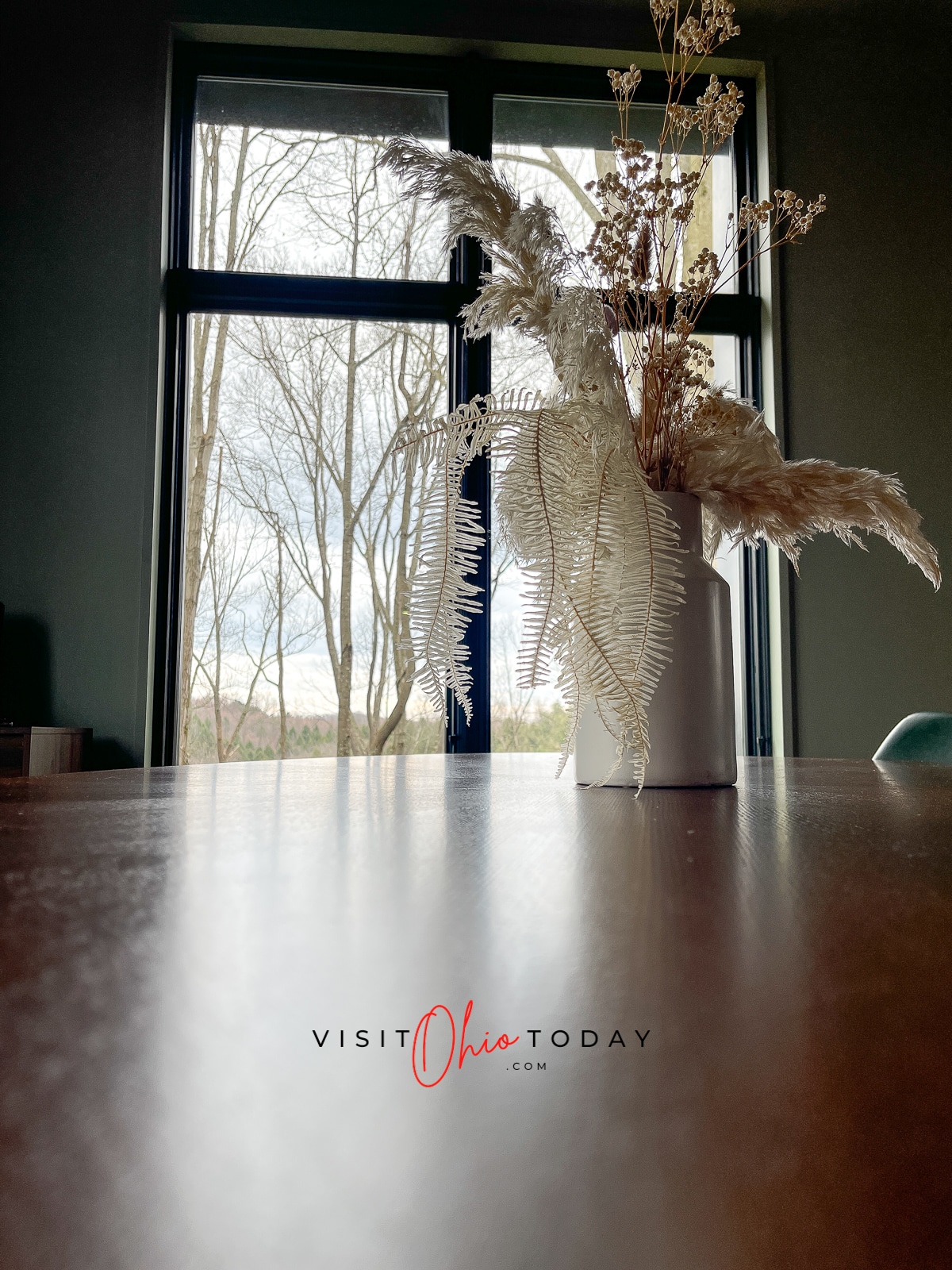 brown table with white vase and feathery things on it and a wall of windows behind it Photo credit: Cindy Gordon of VisitOhioToday.com