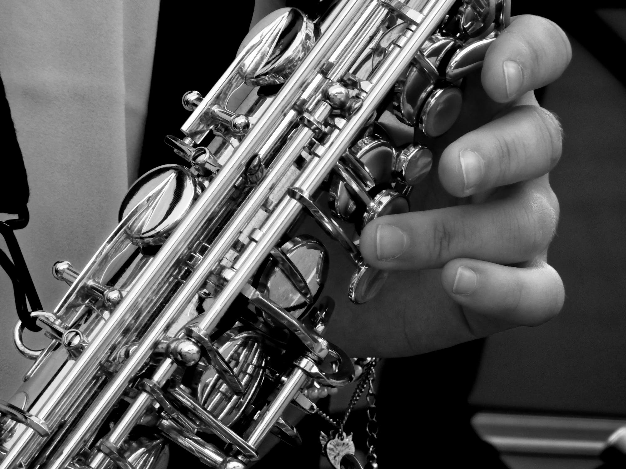 Black & white photo of hands holding a saxophone