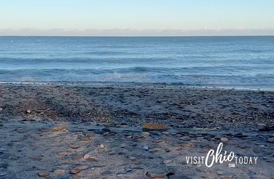 vertical photo of a beach scene of blue sky and blue sea