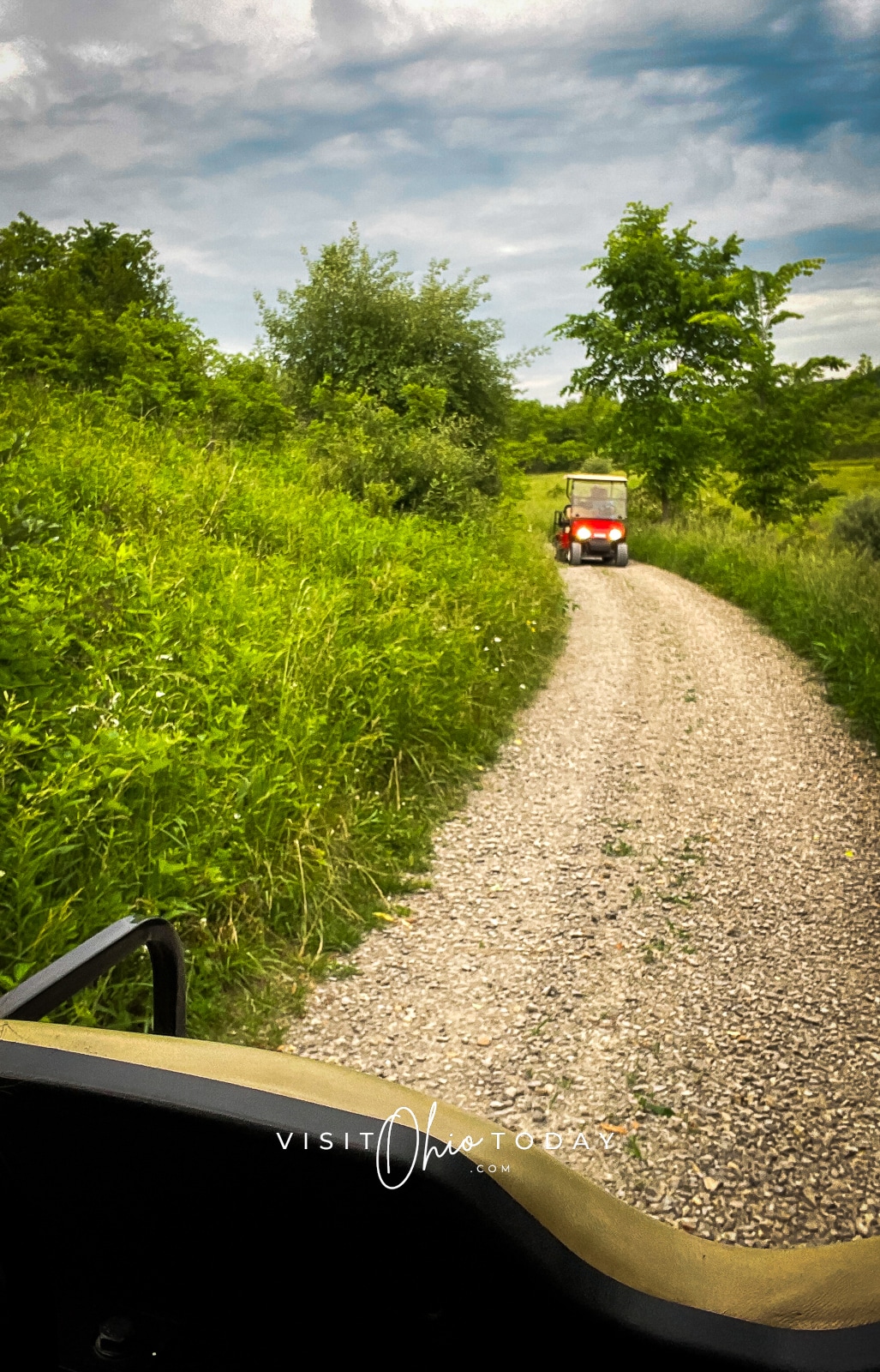 gravel path with red golf cart and headlights on. Lots of green trees and brush Photo credit: Cindy Gordon of VisitOhioToday.com