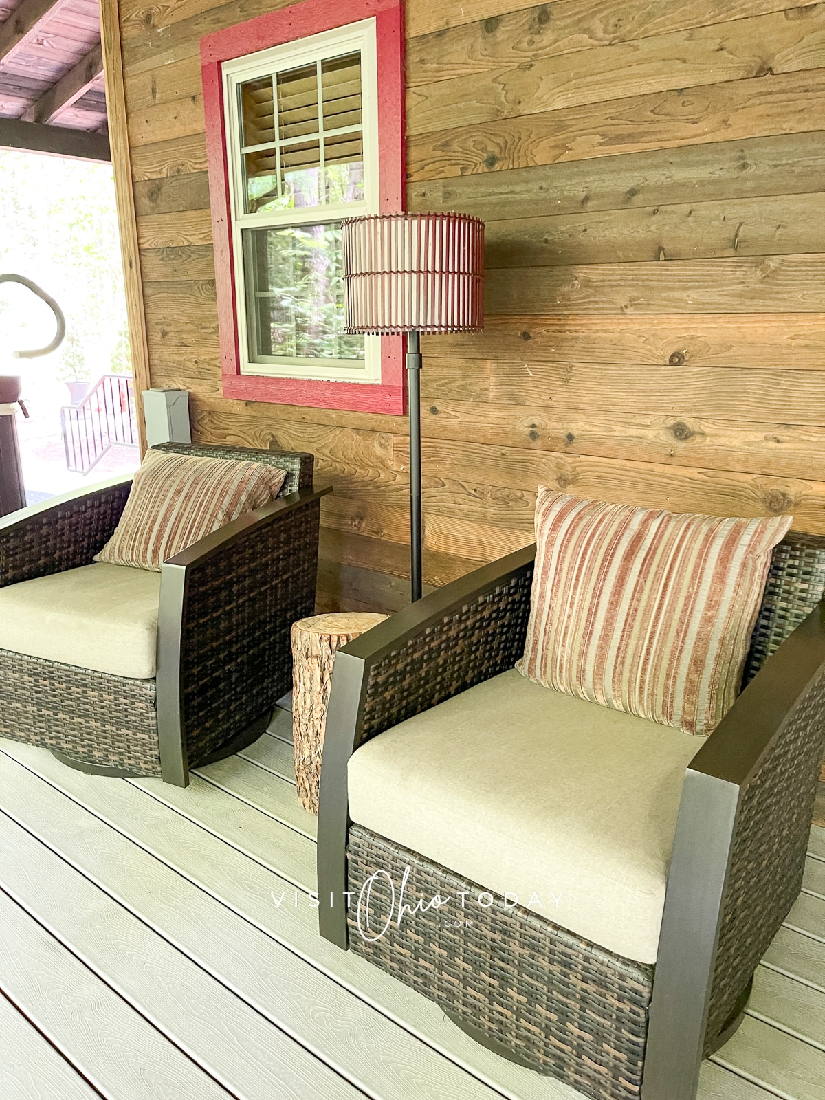two outdoor chairs on covered porch with light inbetween