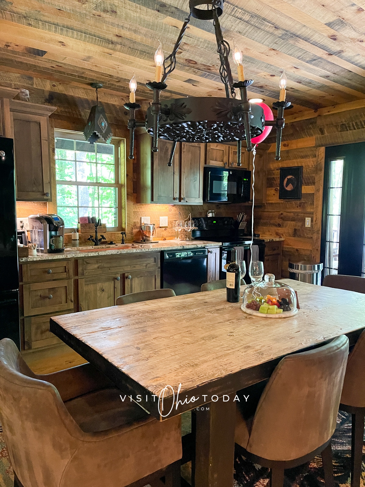 dark wood walls and ceiling kitchen with rectangle table and 3 chairs. Red balloon on string Photo credit: Cindy Gordon of VisitOhioToday.com