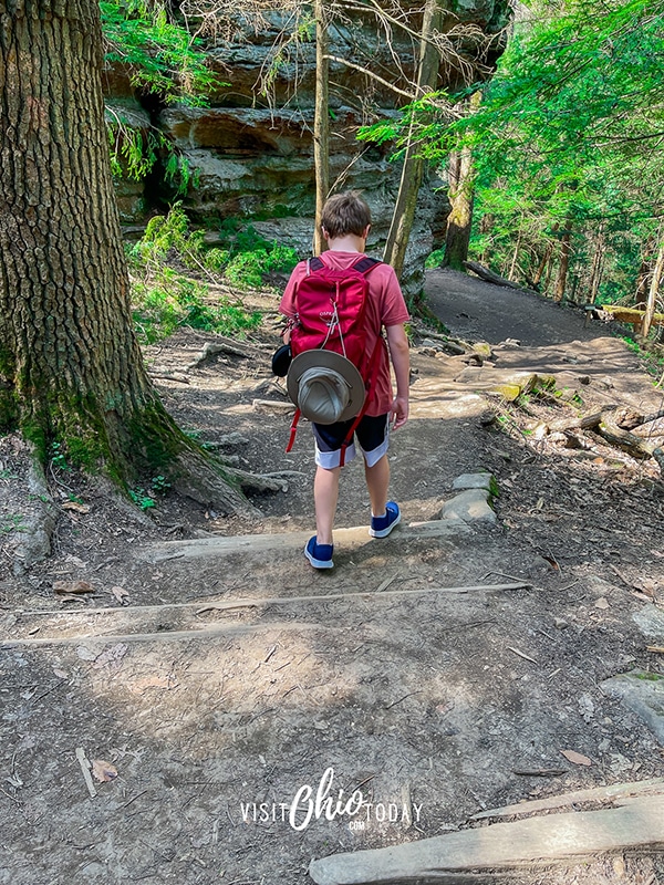 vertical photo of a boy walking the trail to the Rock House. Photo credit: Cindy Gordon of VisitOhioToday.com