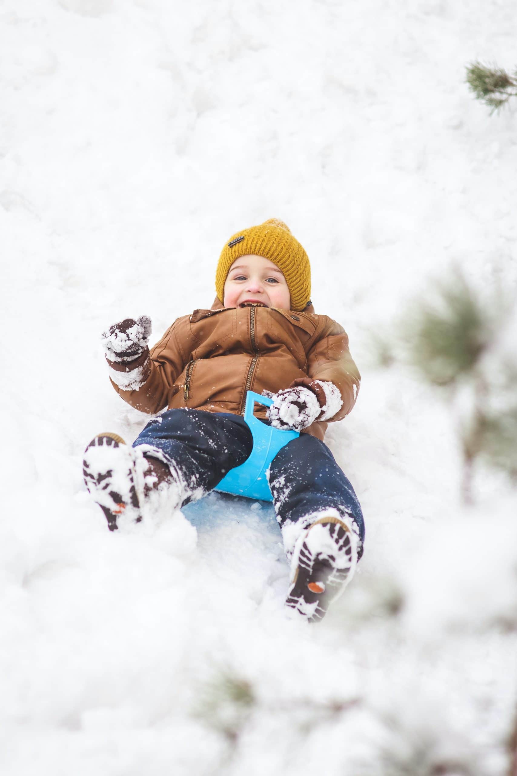 A child sliding down a snowy hill (Ohio Sledding Hills)