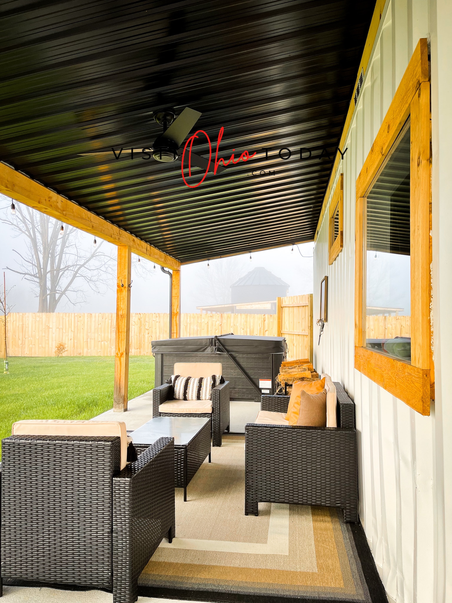 back porch of tiny house with black roof and black patio furuinture