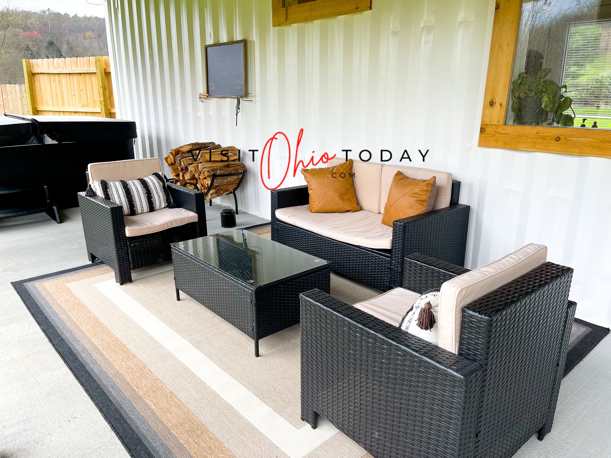 black and tan patio furniture in front of a white container tiny house