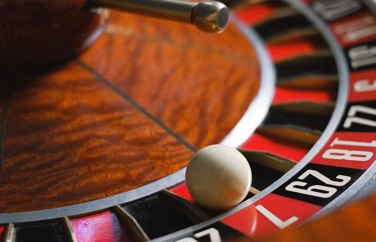 horizontal image of a close up photo of a roulette wheel with the ball in number 7 red