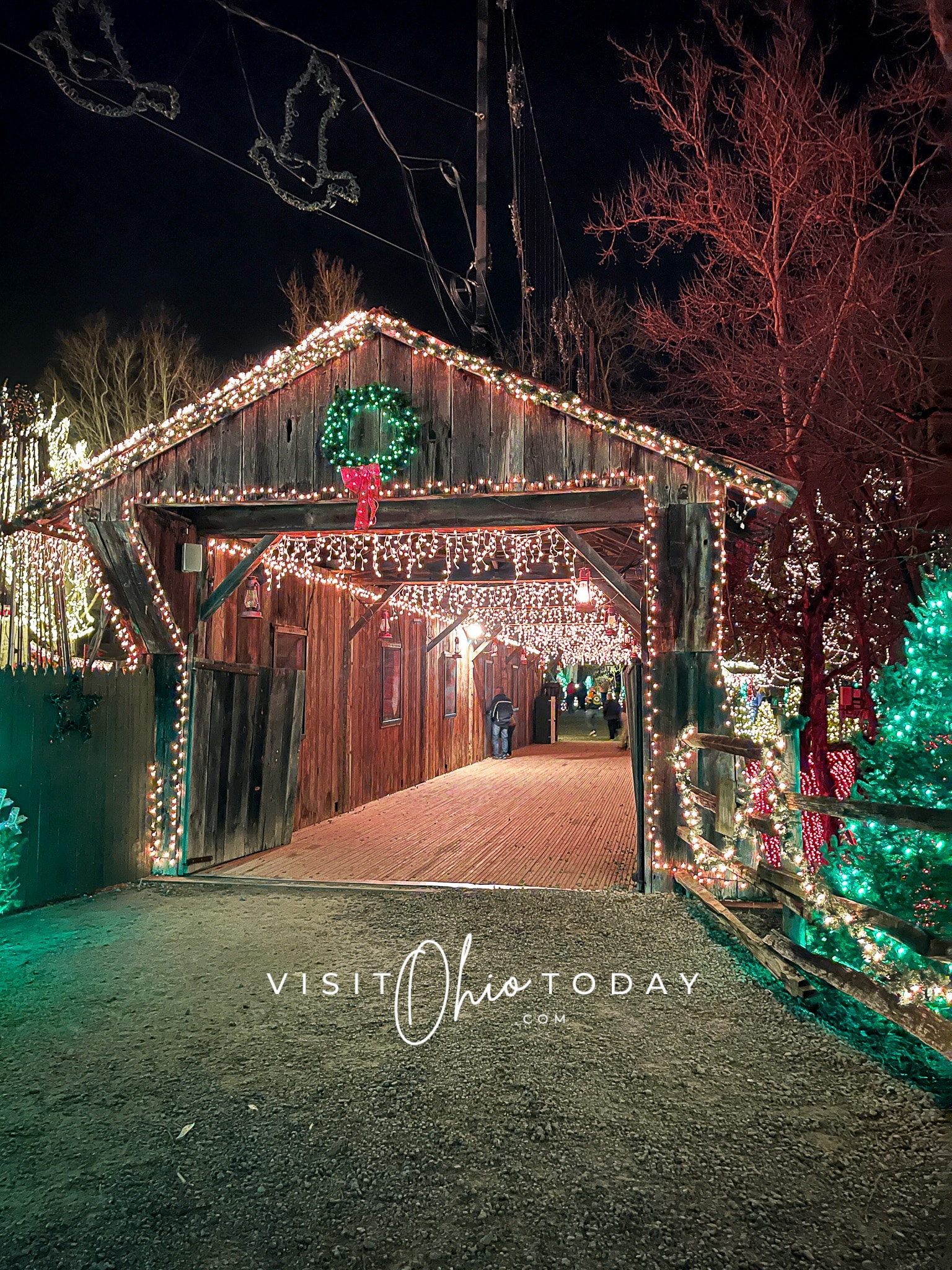 covered bridge at clifton mill, it is decoreated with wreaths and christmas lights