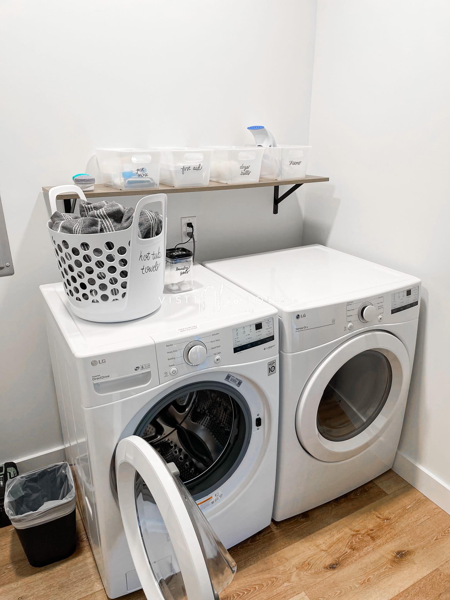 laundry machine with bin of towels on top