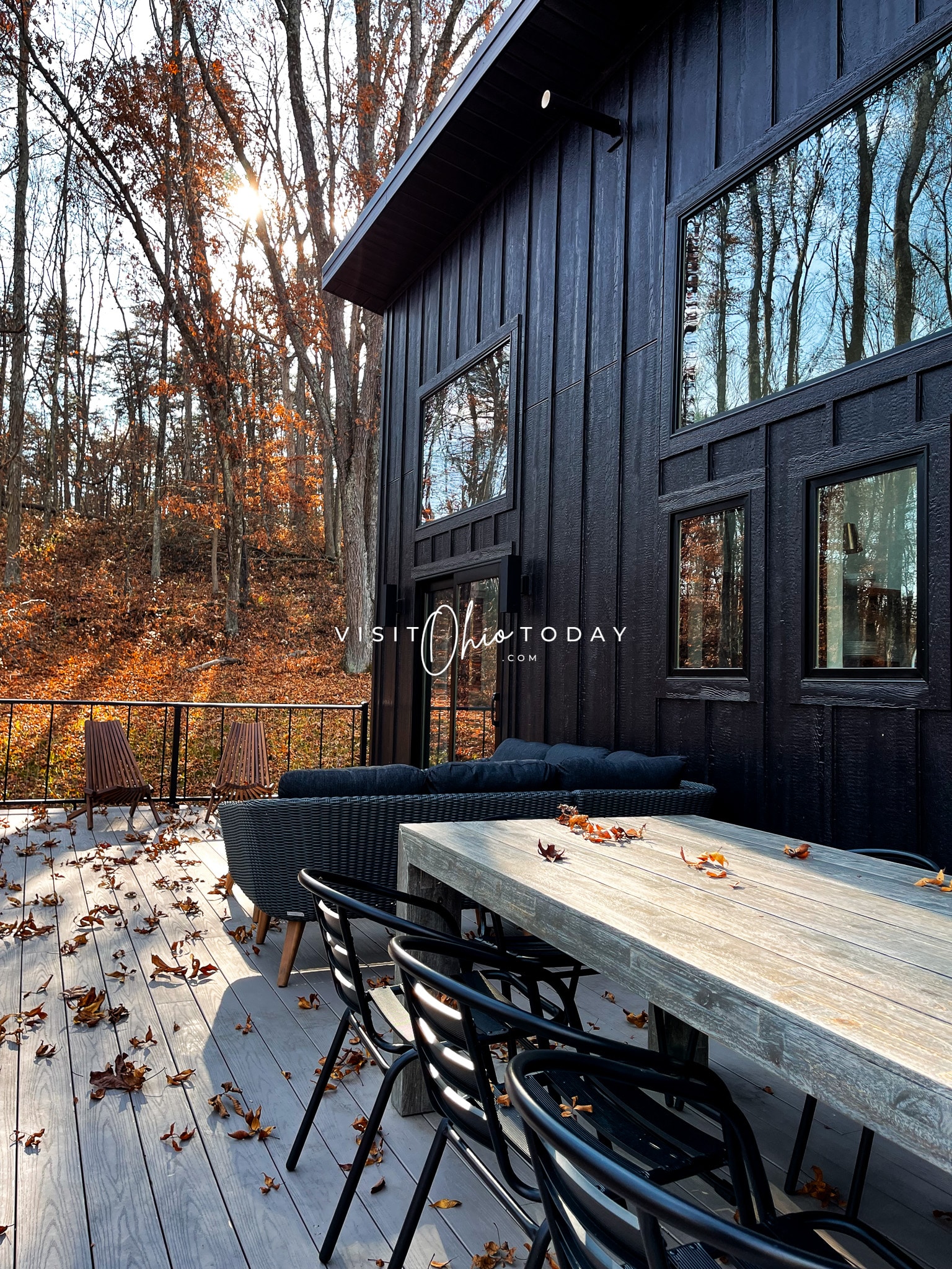 black cabin with big 8 person table and a dark gray l shaped couch Photo credit: Cindy Gordon of VisitOhioToday.com