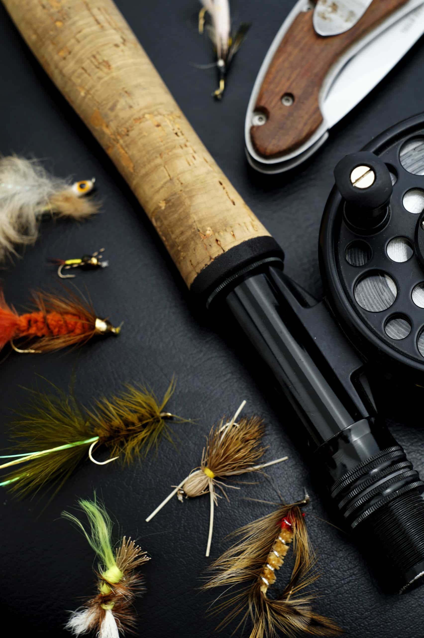 An image of fishing equipment. There is a fishing rod, swiss army knife and fishing floats