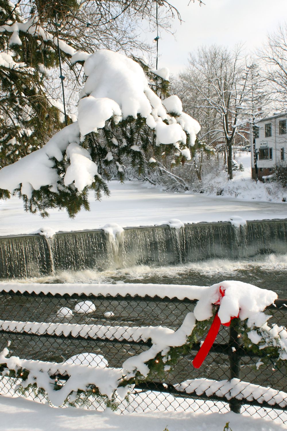 A photo of a frozen waterfall in an area covered in snow