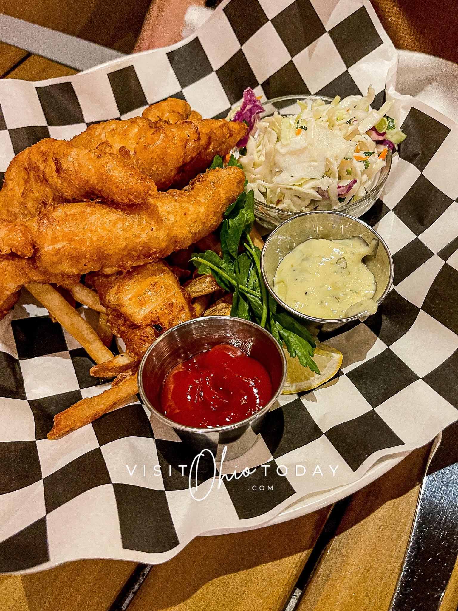 white plate with black and white checked paper on it. Breaded fish strips, sauces and coleslaw Photo credit: Cindy Gordon of VisitOhioToday.com