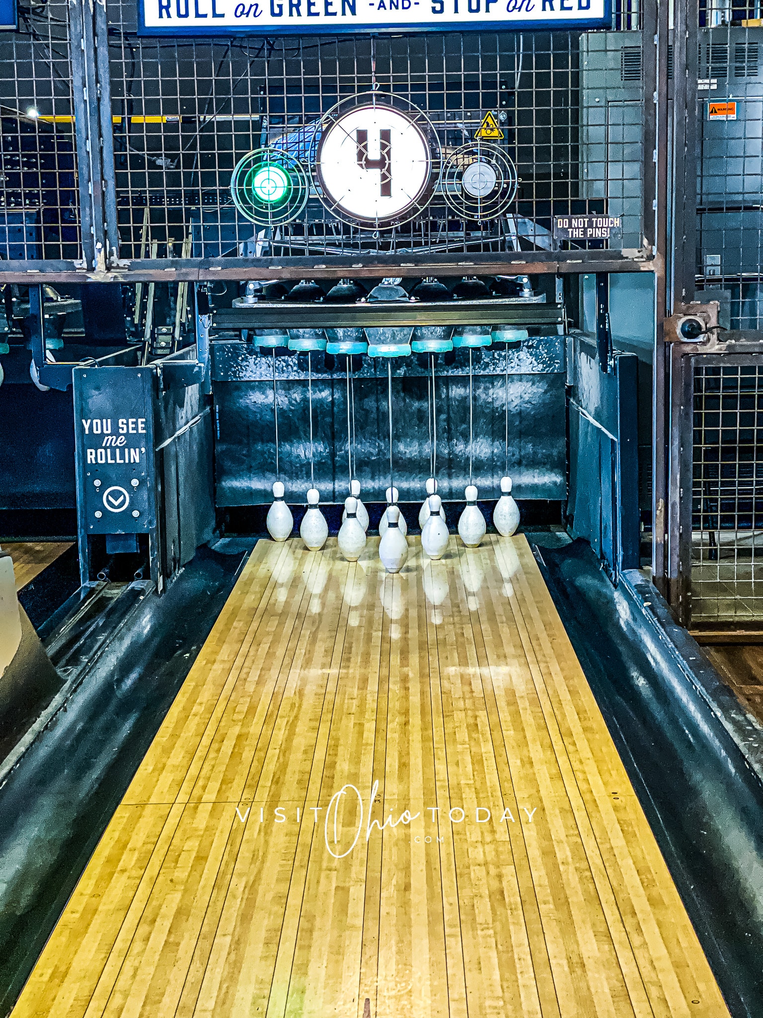 picture of a duck pin bowling alley. wooden brown floor with a #4 up top of the metal cage that is over the duck pins Photo credit: Cindy Gordon of VisitOhioToday.com