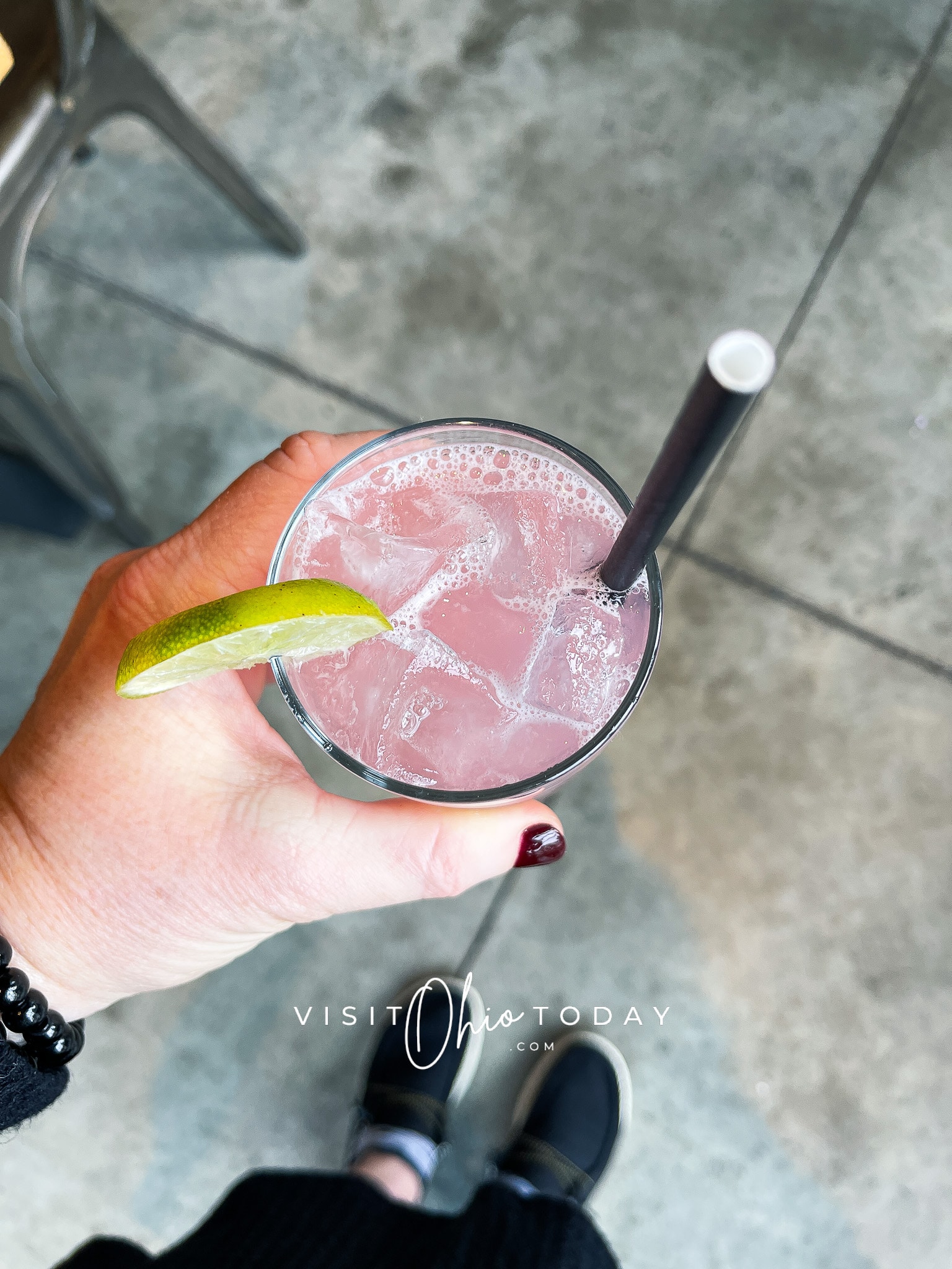 hand holding a glass with pink liquid, ice and a black straw Photo credit: Cindy Gordon of VisitOhioToday.com