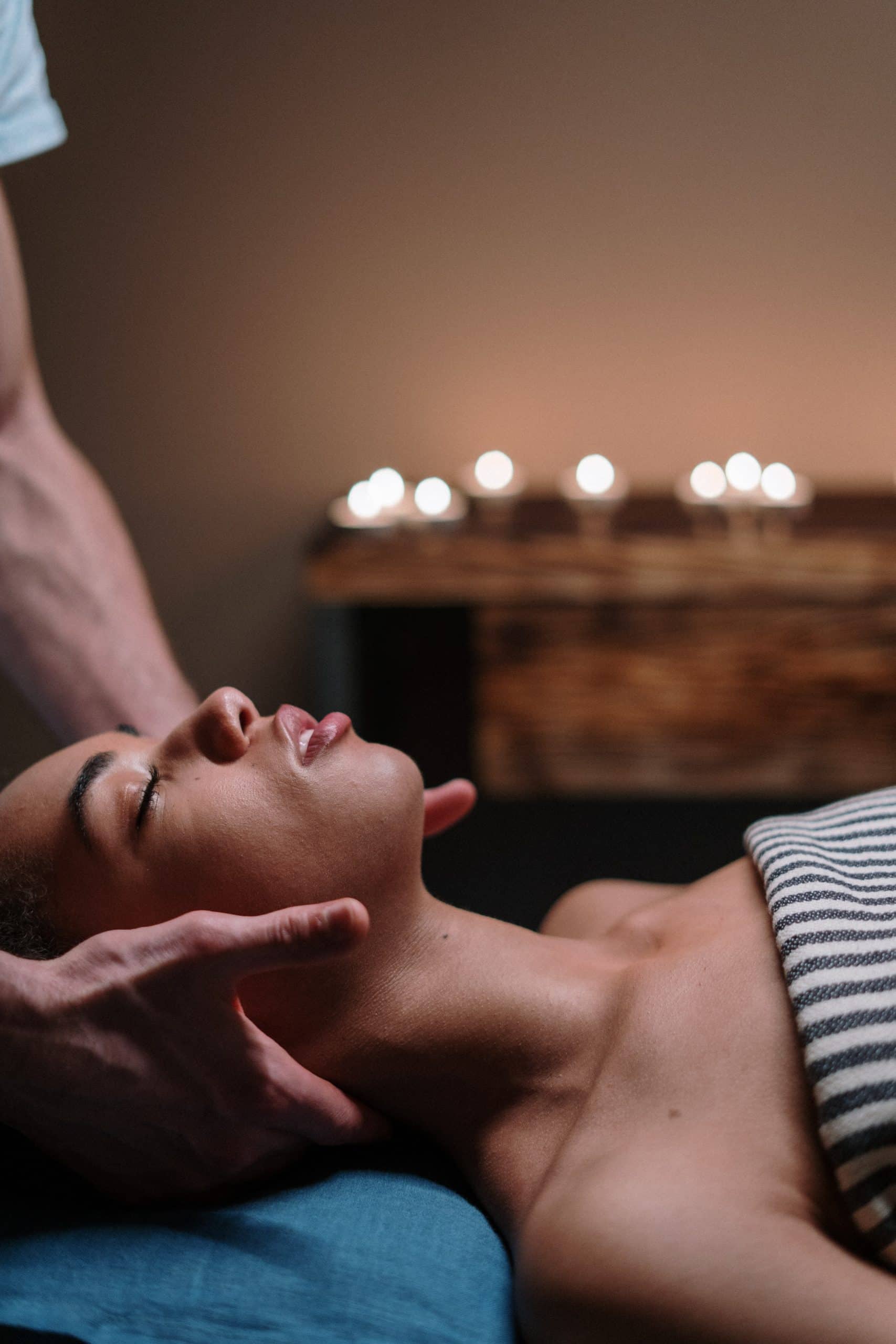 A female laying on a table receiving a facial massage