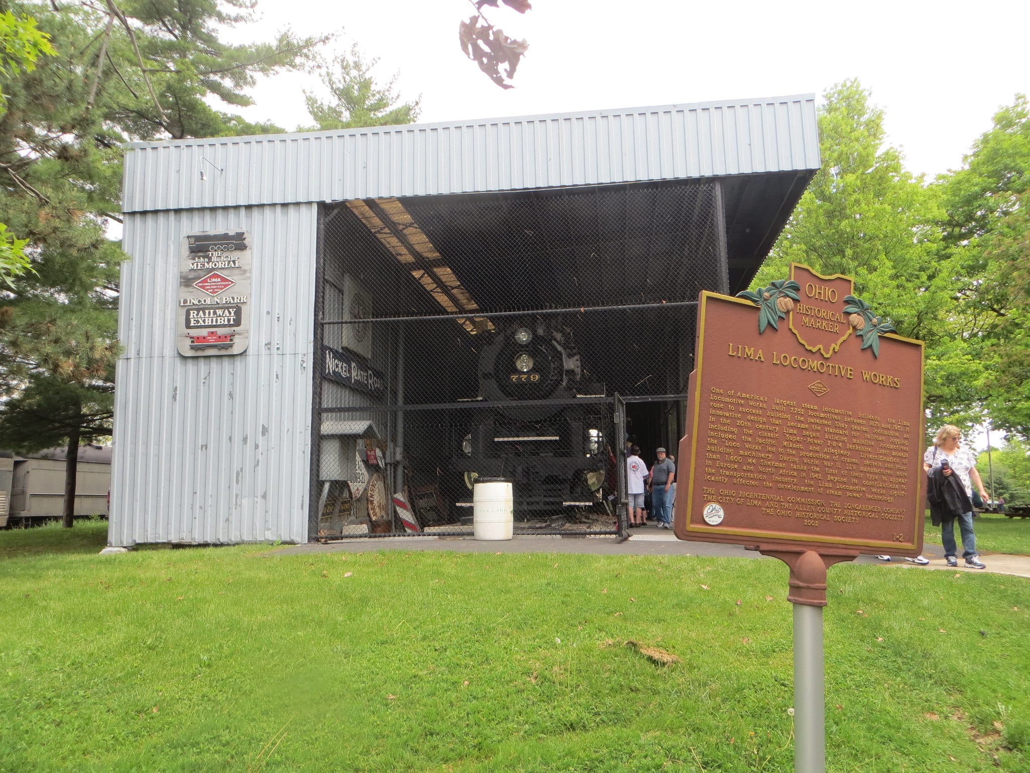 horizontal photo of an exhibit at the Lincoln Park Railway Exhibit, with the historical marker sign in the foreground