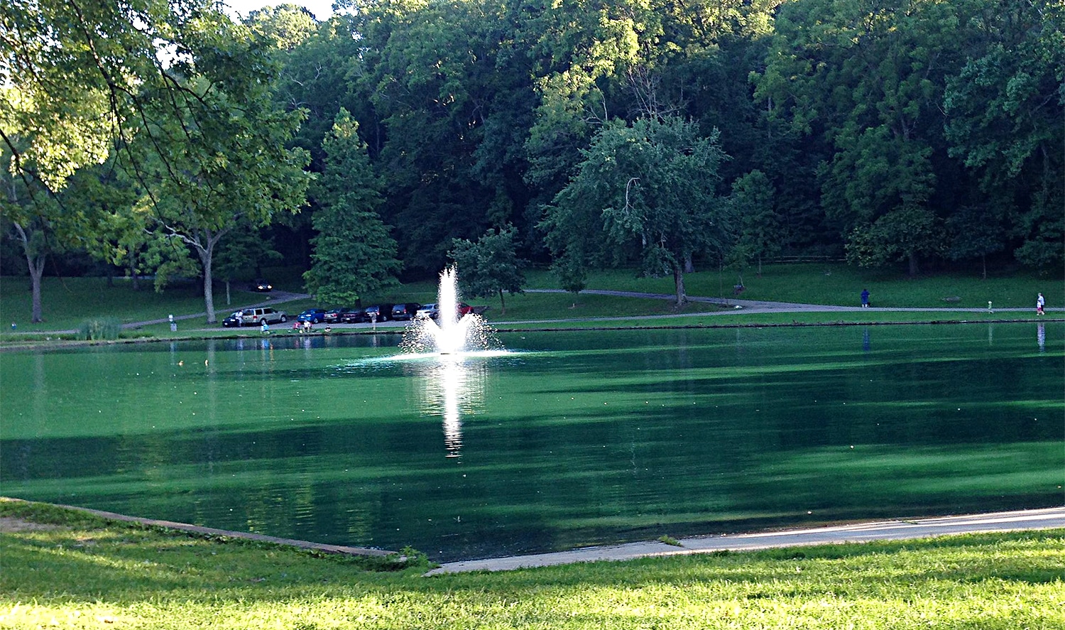 horizontal photo of the lake at Rising Park with the car park in the background