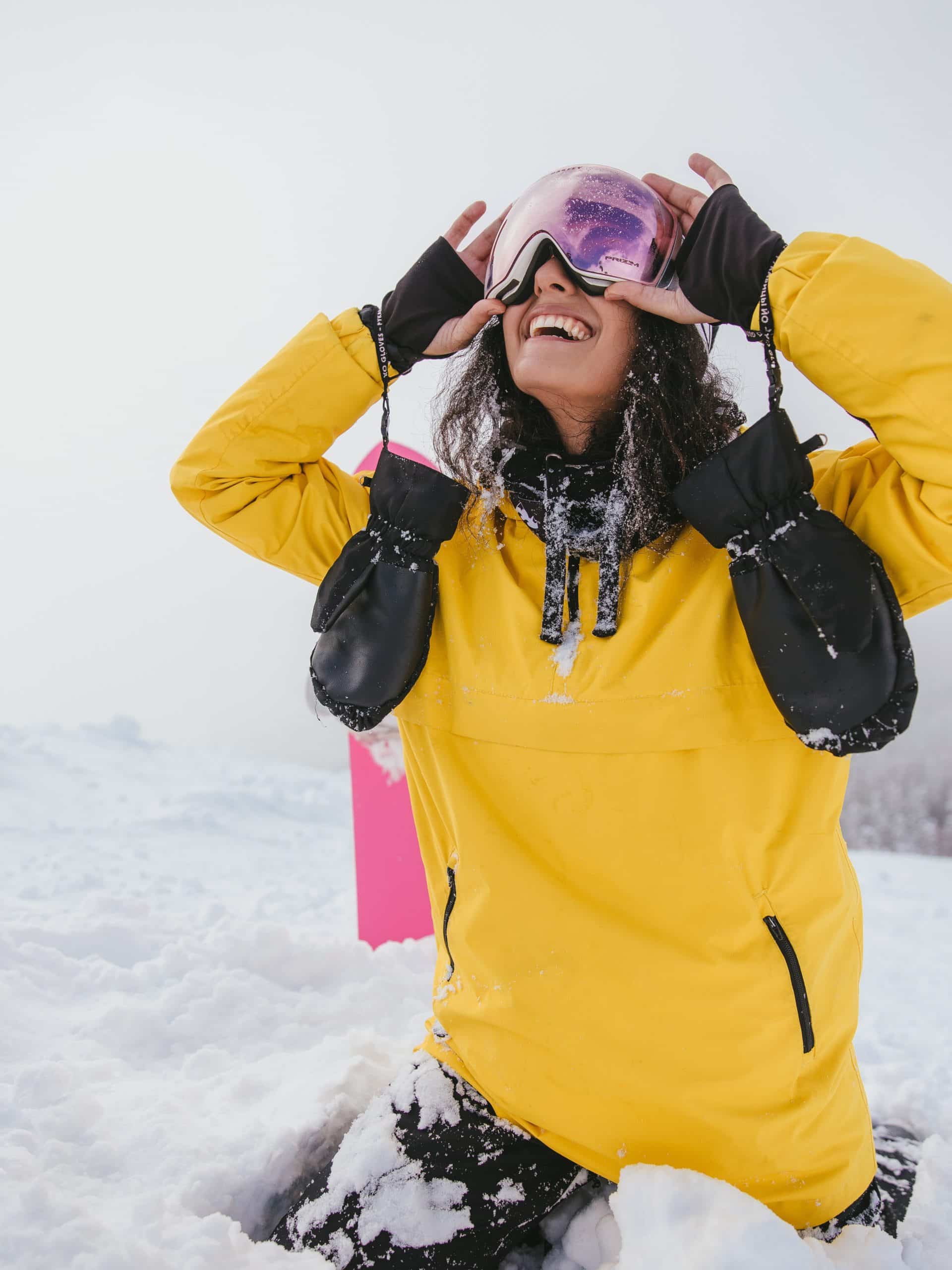 A female wearing a yellow jacket sat in the snow