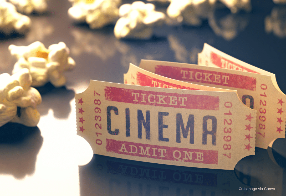 horizontal photo of cinema tickets and popcorn scattered on a glossy tabletop
