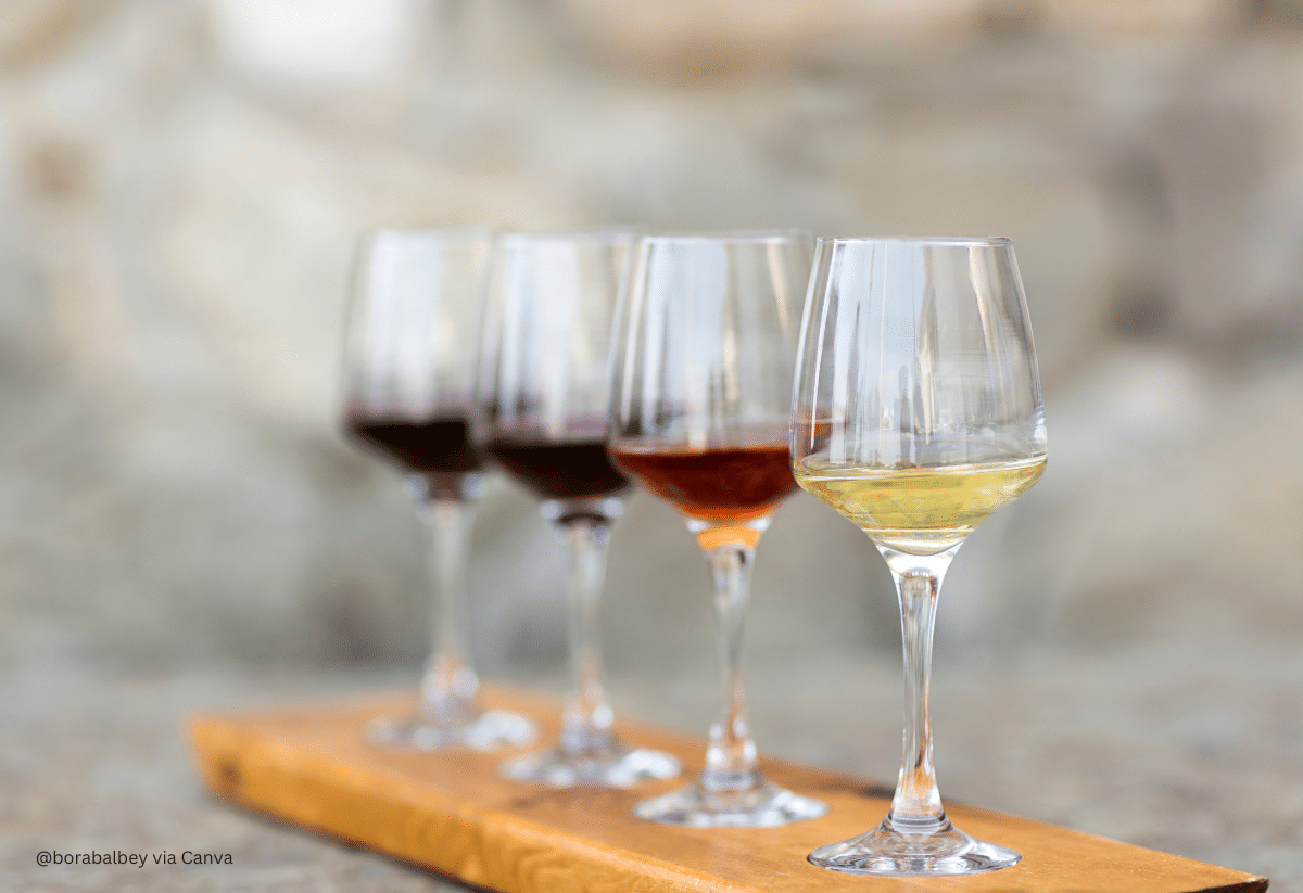 horizontal photo of a 4-glass wine flights with a gray blurred background