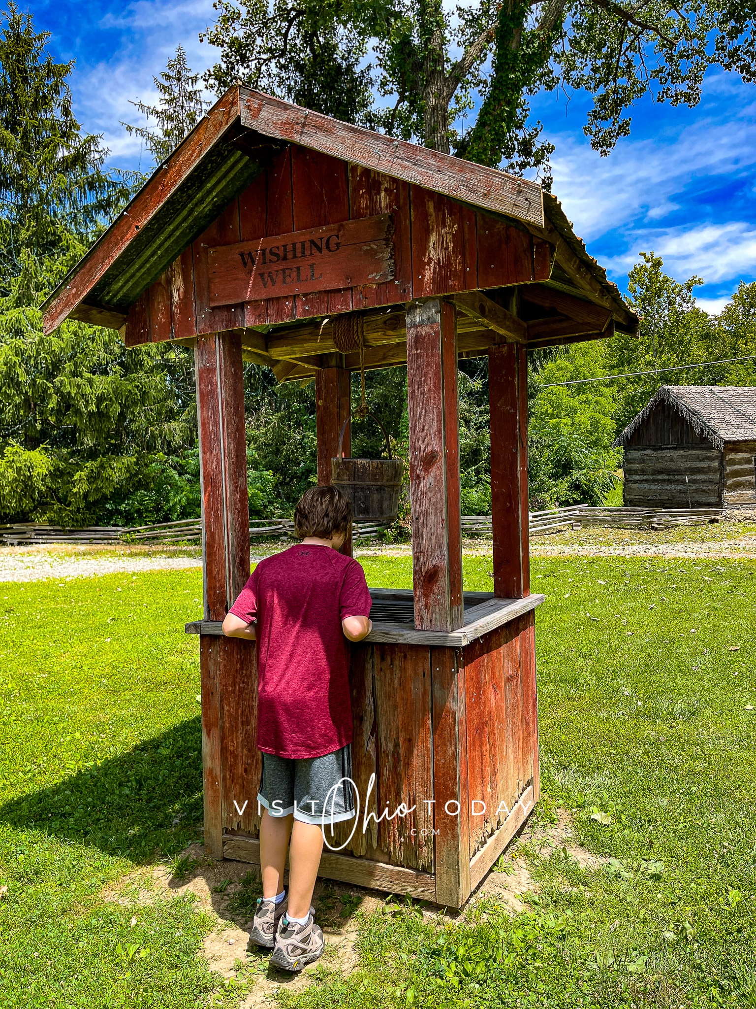 vertical photo of the wishing well at clifton mill with a boy looking into it Photo credit: Cindy Gordon of VisitOhioToday.com