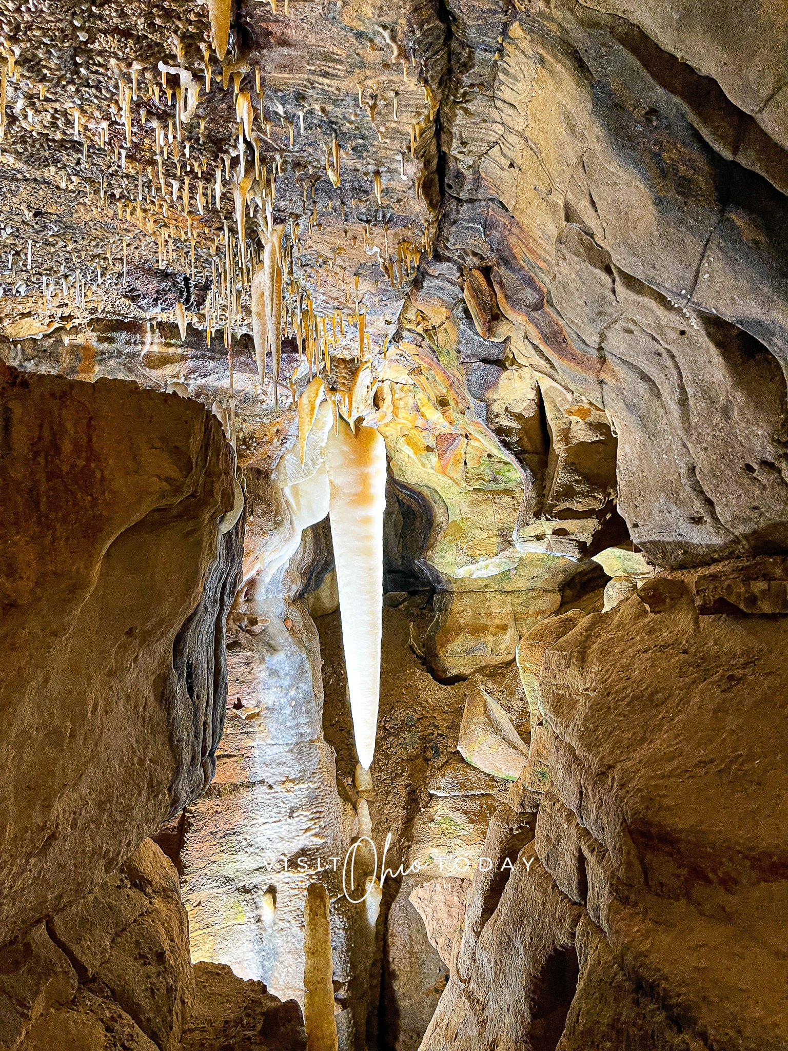 vertical photo of the ohio caverns, showing stalagmites and stalactites and beautifully colorful rock formations