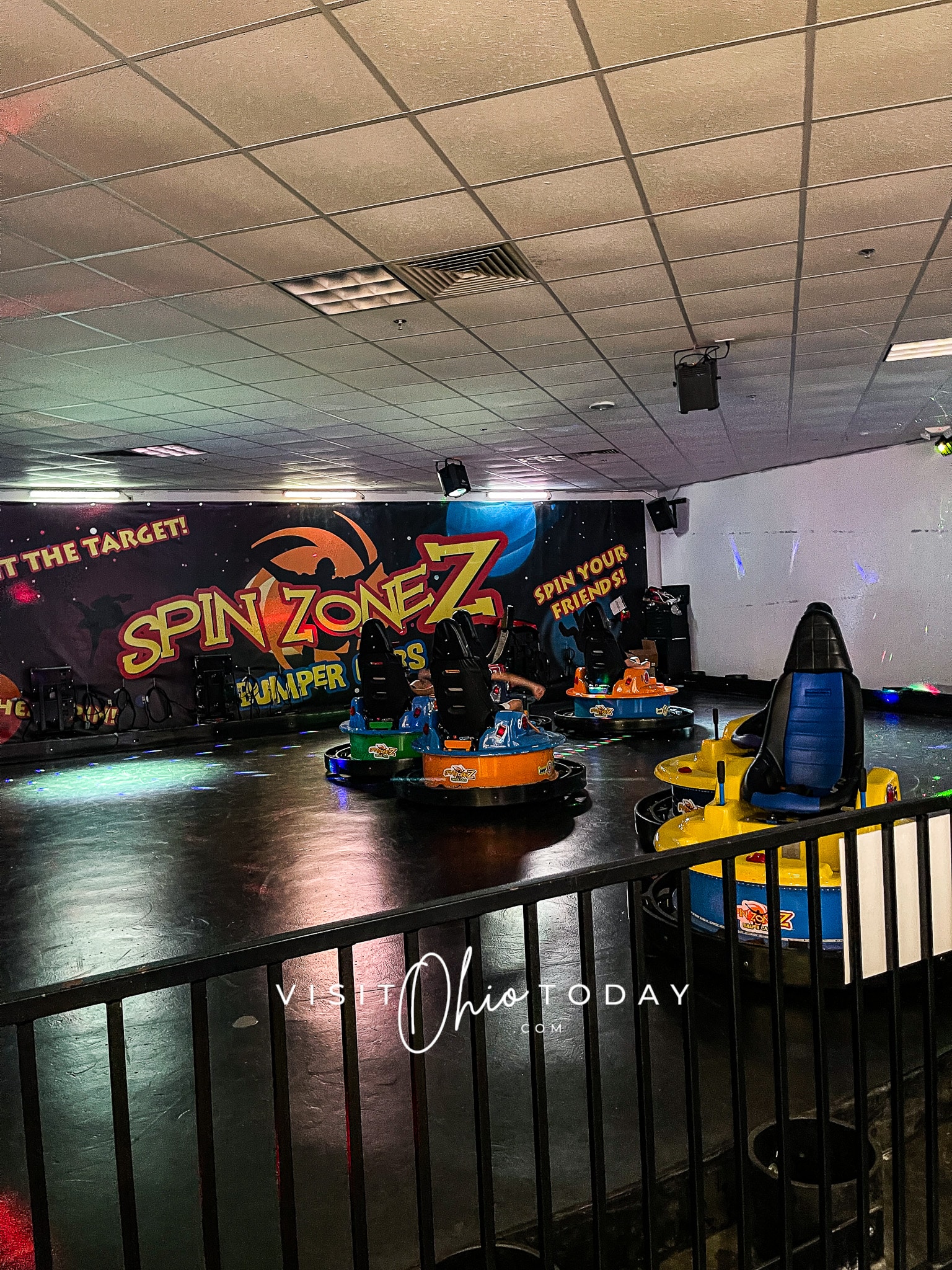 Vertical photo showing the spin zone bumper cars in their arena with 3 occupied cars