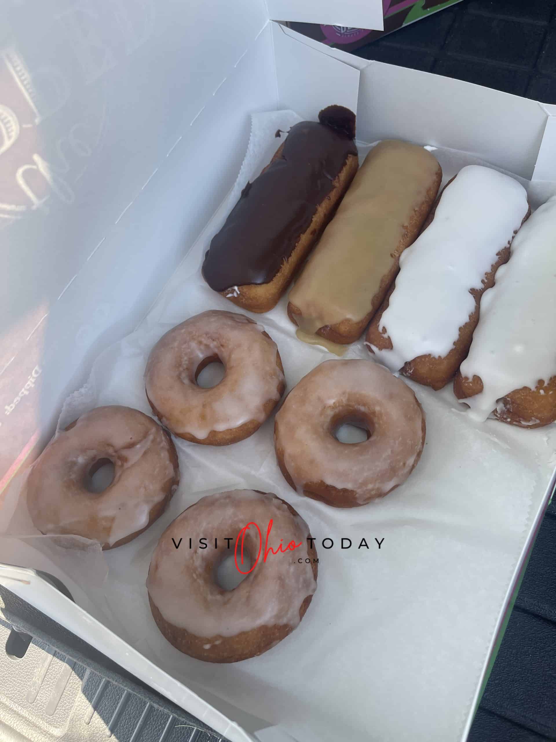 vertical photo showing a box of donuts from gluten free from the dipped. 4 round donuts and 4 finger donuts Photo credit: Cindy Gordon of VisitOhioToday.com