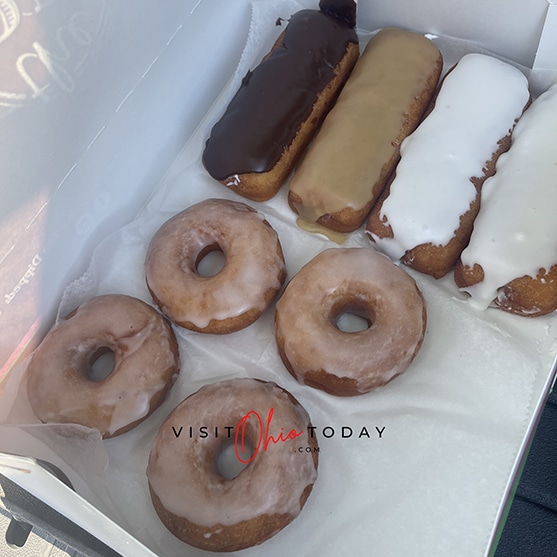 square photo of a box of donuts - 4 round donuts and 4 finger donuts