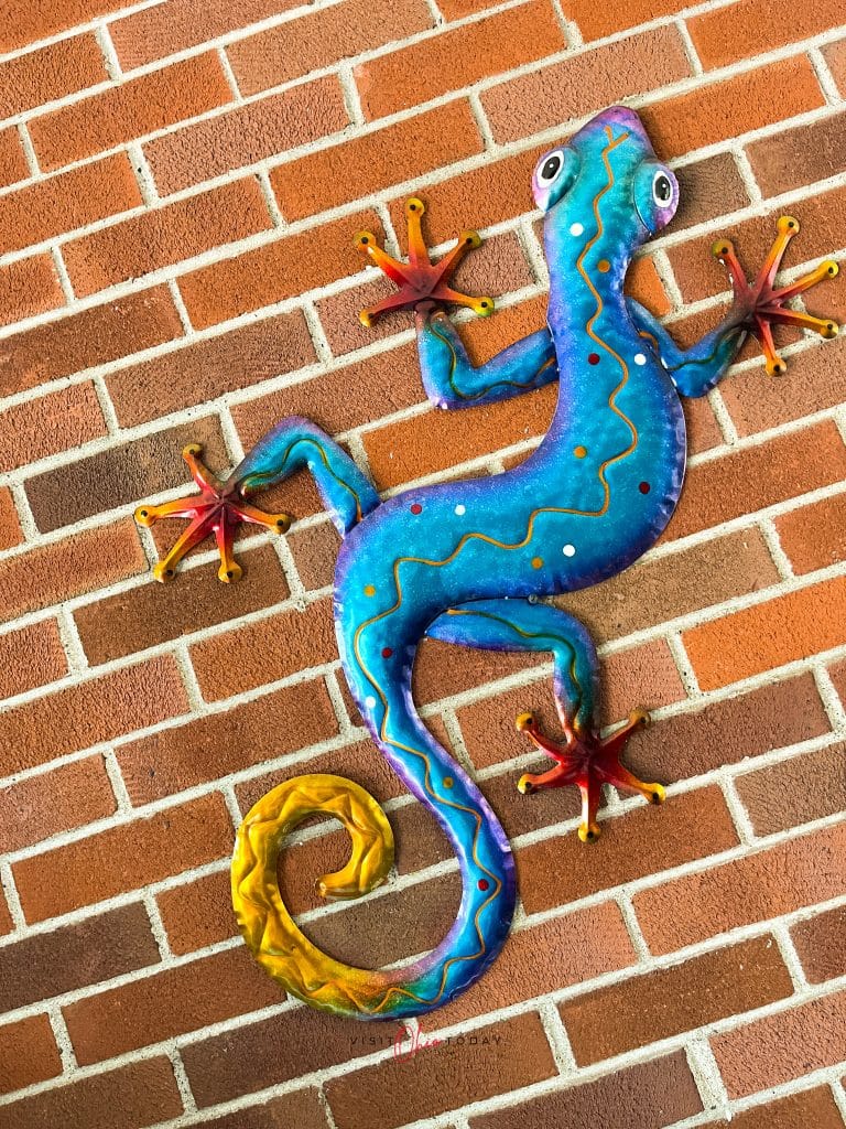 metal blue gecko on brick wall