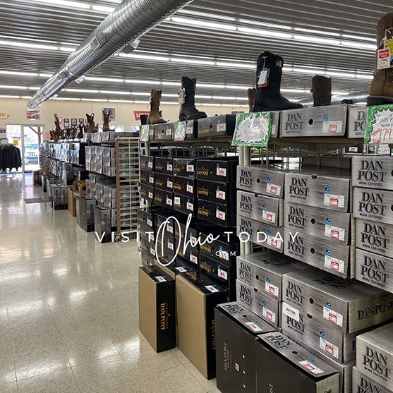 square photo showing a display of various styles of boots in the boot shop outlet