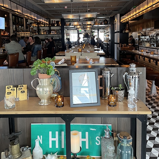 square photo of the inside of the pearl dublin with a display of jugs, pots and bottles in the foreground, and the main dining area in the background